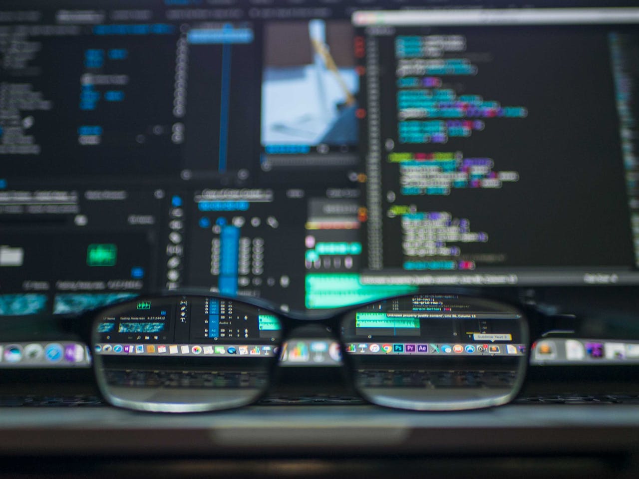 portfolio-01 Eyeglasses reflecting computer code on a monitor, ideal for technology and programming themes.